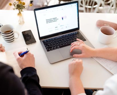 Business professionals comparing website platform options on a laptop