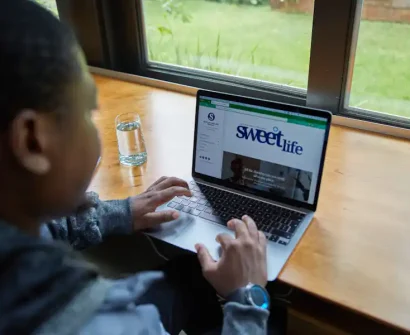 African web professional working on a laptop while maintaining client websites